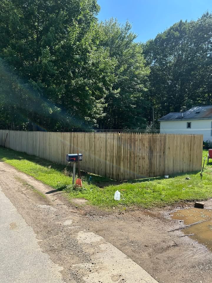 Wood stockade fence installed along a roadside property line