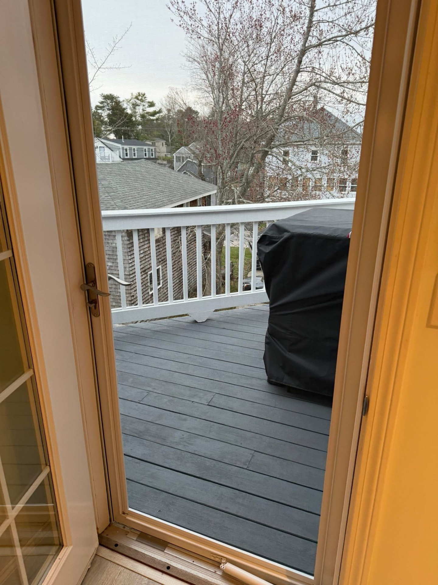 Gray composite deck with white railing off a second-floor door