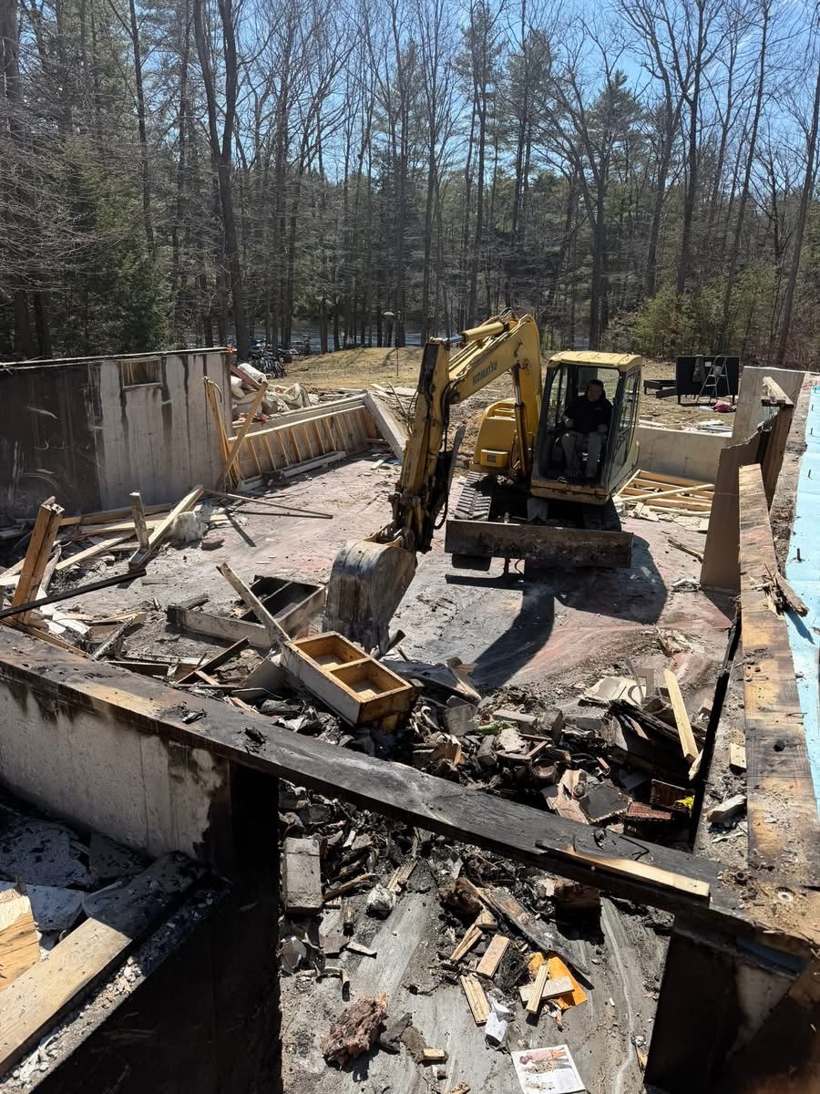 Excavator performing structure demolition down to the foundation