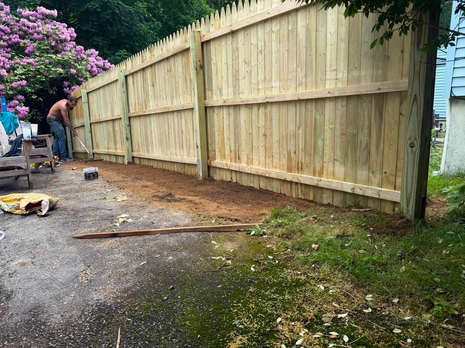 Wood stockade privacy fence installed along a driveway