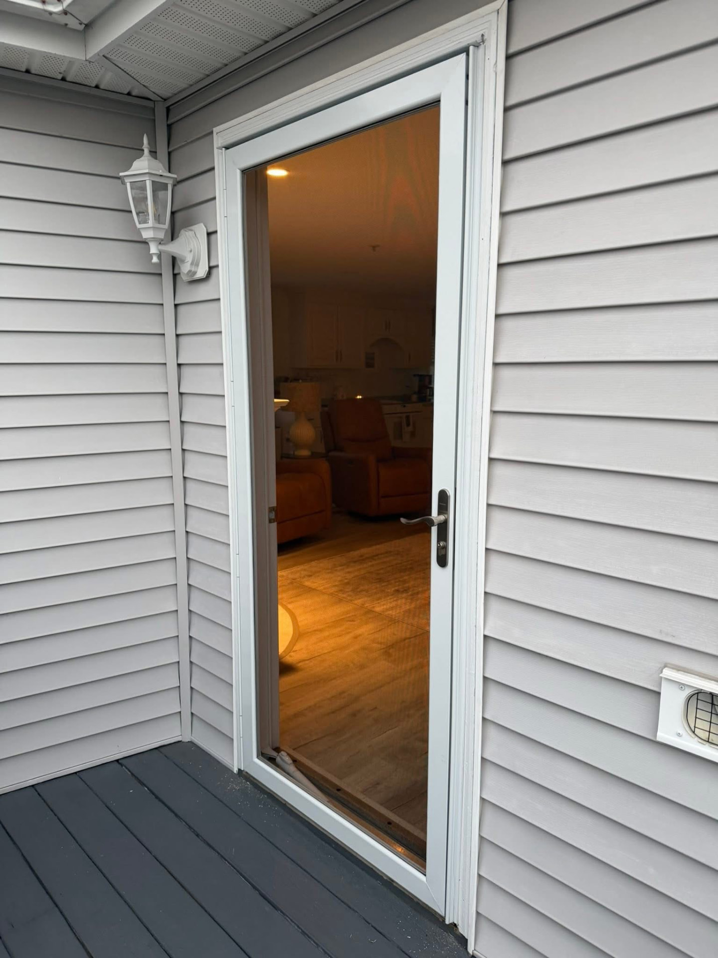 New exterior door and storm door installed on a vinyl-sided home
