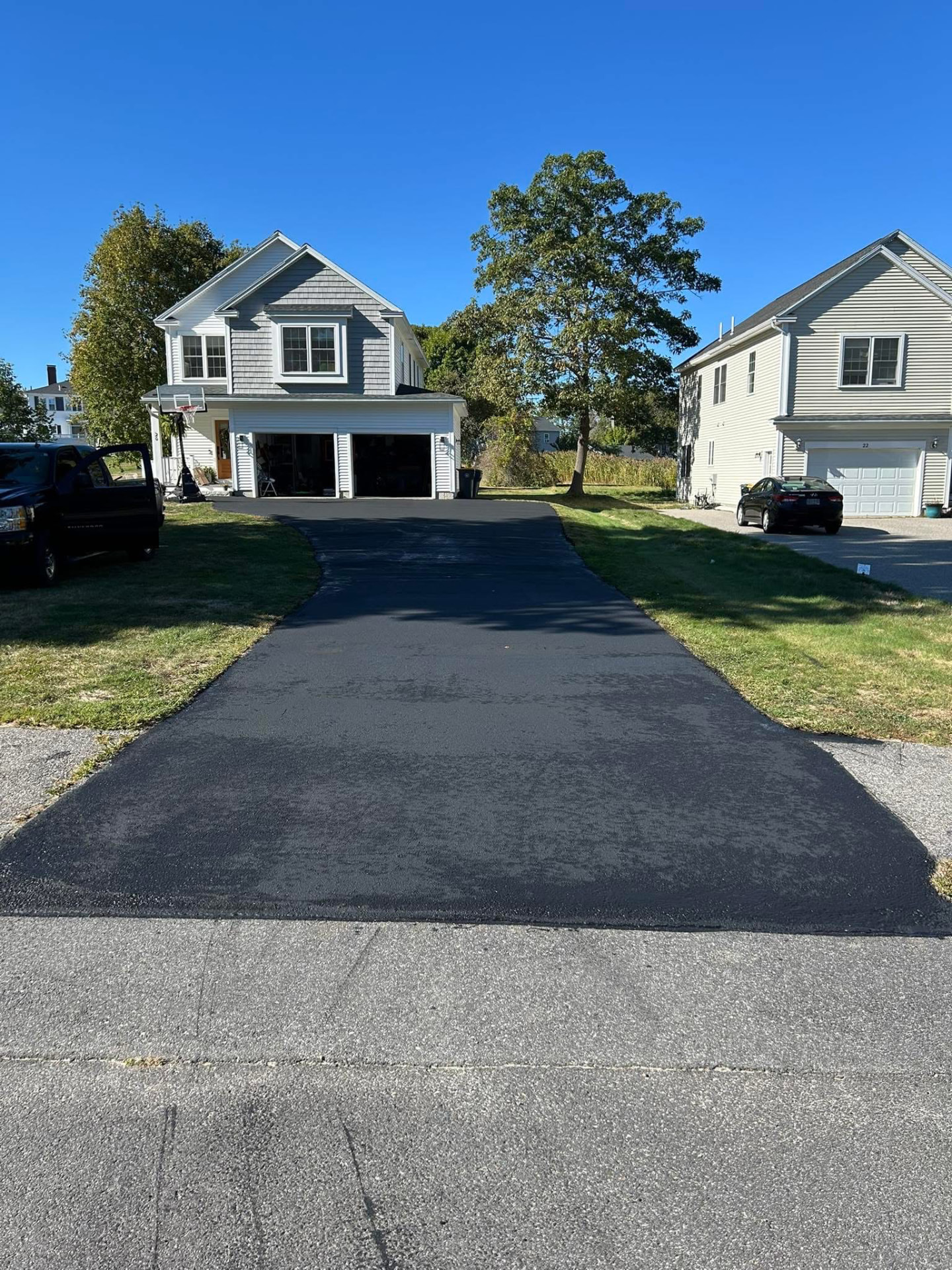 Freshly finished driveway and cleared front yard at a Maine home