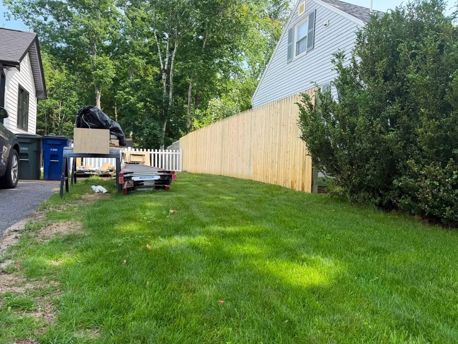 New wood stockade privacy fence running along a side yard
